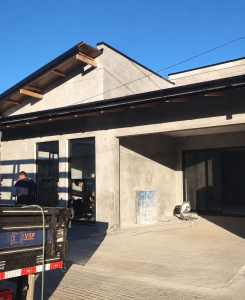 Reforma residencial moderna em fase de execução com fachada contemporânea, esquadrias em alumínio preto, cobertura metálica e acabamentos arquitetônicos desenvolvidos pela Antoni Engenharia.